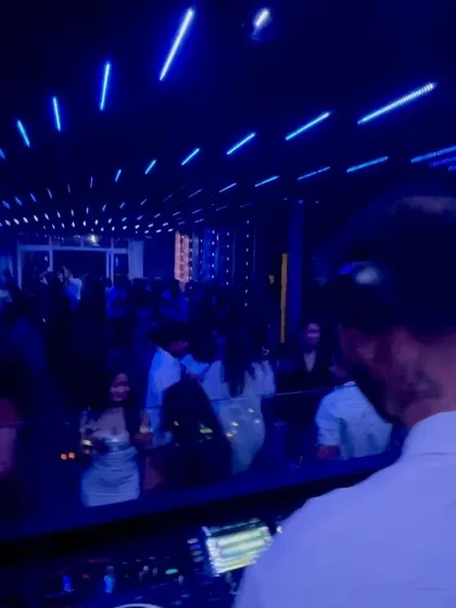 A serene moment under the blue lights, but the energy is still simmering, ready for the next drop.