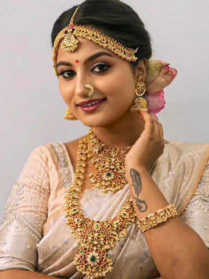 A closer look at the intricate details of the Kempu choker and haram. The red and green stones are characteristic of traditional South Indian bridal jewellery.