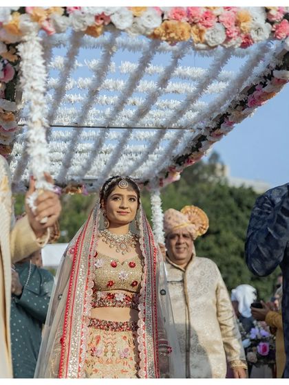 The bride's entrance under a phoolon ki chaadar. Her calm and happy expression as she walks towards the mandap is a beautiful moment to capture.