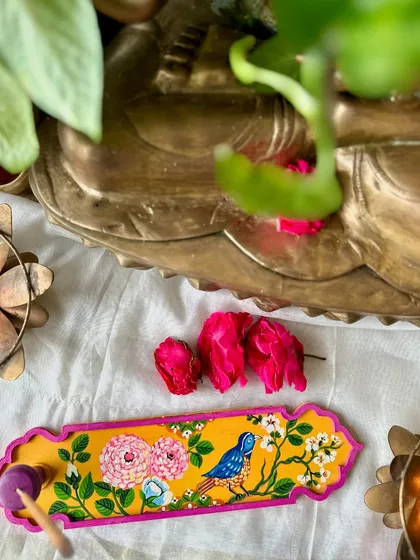 A cheerful yellow incense holder painted with peonies and a little bluebird.