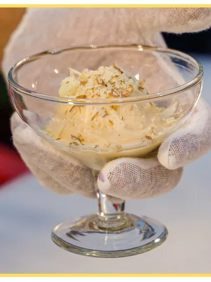 A scoop of ice cream topped with crunchy nuts, showcasing one of the many options available at our live dessert stations.