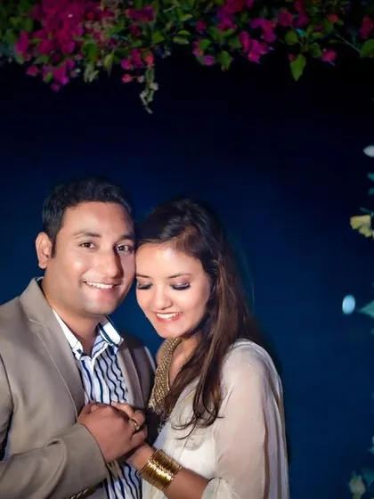A sweet and simple portrait under a floral arch at night. The focus is entirely on the couple's happy and loving connection.