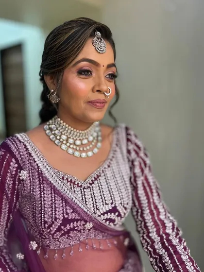 A happy client in a deep purple lehenga with silver work. She looks absolutely ready for a sangeet night.