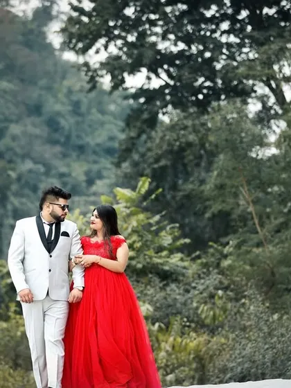 A couple shares a romantic walk through a forest path for their pre-wedding shoot. The natural surroundings and their elegant attire create a fairytale-like atmosphere.