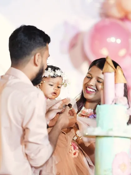 A happy family celebrating their daughter's first birthday with a beautiful castle-themed cake. These are the moments that make our work so rewarding.