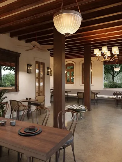 The ground-floor patio offers a covered dining experience that still feels connected to the outdoors. Exposed wooden beams and pillars were preserved and reinforced, maintaining the home's original architectural language.