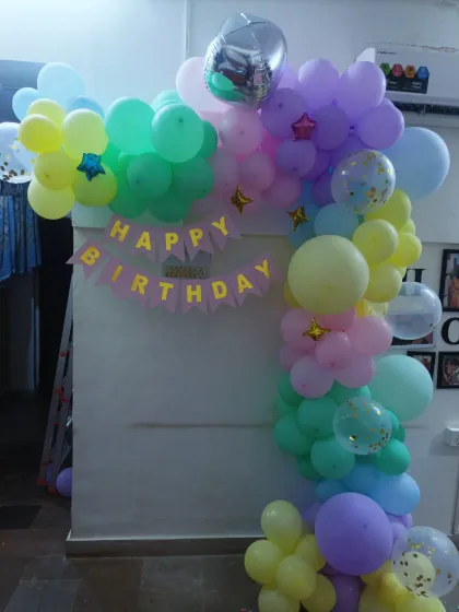 A slightly different angle of the pastel balloon arch, showing its placement in a living room.