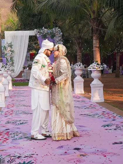 A romantic shot of the couple on their floral-printed aisle. The soft lavender color palette and the natural outdoor setting make this a truly dreamy and intimate moment.