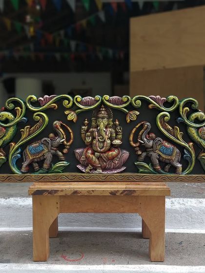 A 36-inch Gaja Ganesha wall panel in a multicolored finish, displayed in our workshop. This piece features Ganesha flanked by elephants and peacocks.