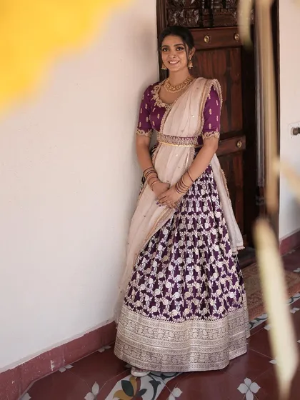 A full-length shot of our client in the purple brocade lehenga, a picture of elegance and poise.