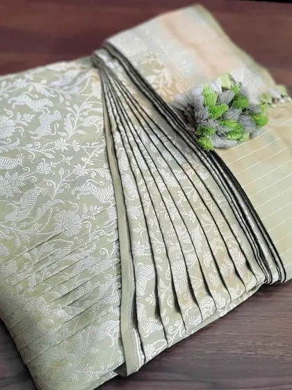 A light green Banarasi saree, pre-pleated and folded. This shows how I handle even heavily woven sarees, making them easy to manage.