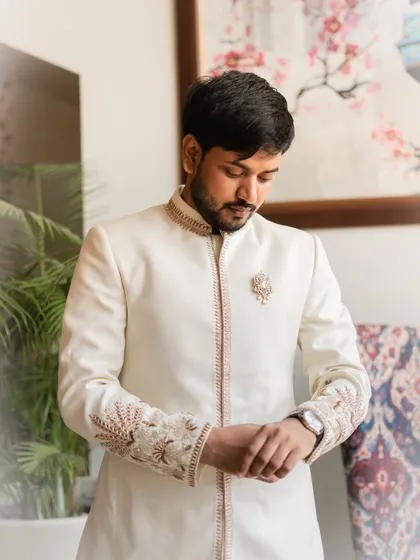 A portrait of the groom getting ready, adjusting his watch before the engagement ceremony. I capture these moments of quiet preparation, highlighting the details of the groom's attire and his anticipation for the event.