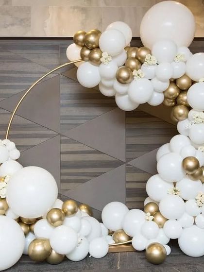 An elegant and clean balloon arch decoration in white and gold. This half-arch design is perfect for framing a corner or entrance, adding a touch of class to any anniversary or engagement party.