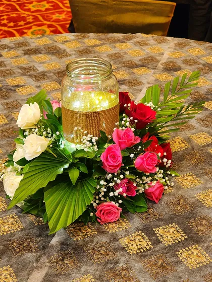 A centerpiece for the Sufi Night event, featuring a glass jar with fairy lights surrounded by pink and white roses. This simple yet elegant detail adds a warm and magical glow to each table.