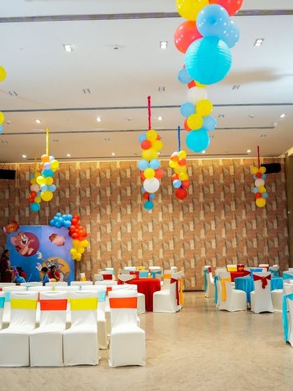 The party hall is fully decorated with colorful balloons and themed table settings for the Tom & Jerry celebration.