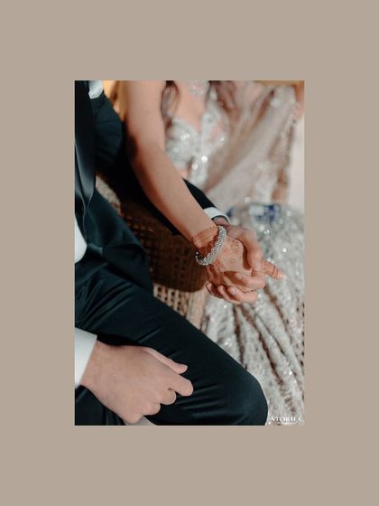 A close-up detail shot of the couple holding hands, a simple yet powerful symbol of their connection.