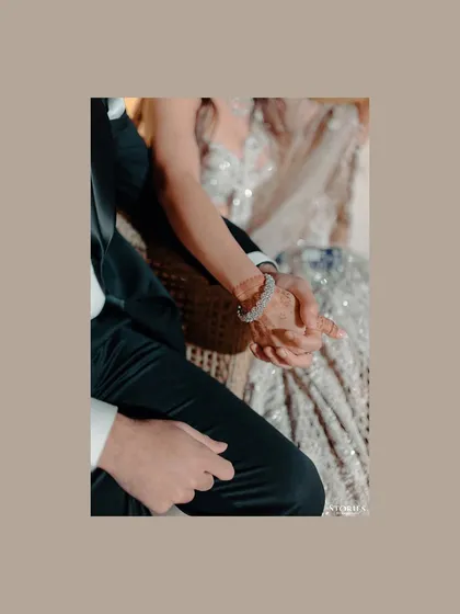 A close-up detail shot of the couple holding hands, a simple yet powerful symbol of their connection.