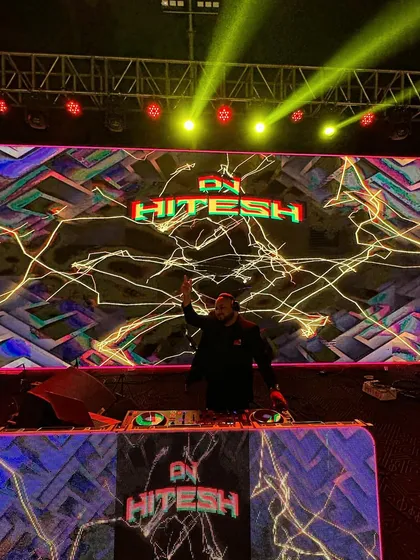 A wide shot of the impressive stage setup. The combination of the massive LED screen and overhead lighting rig creates a true concert feel.
