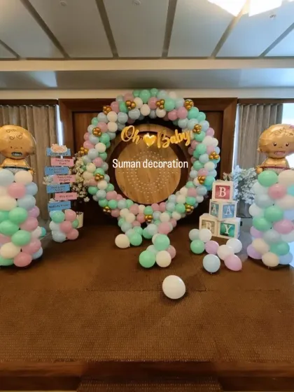 An 'Oh Baby' themed baby shower with a pastel balloon ring. The setup includes 'BABY' blocks and foil balloon columns.
