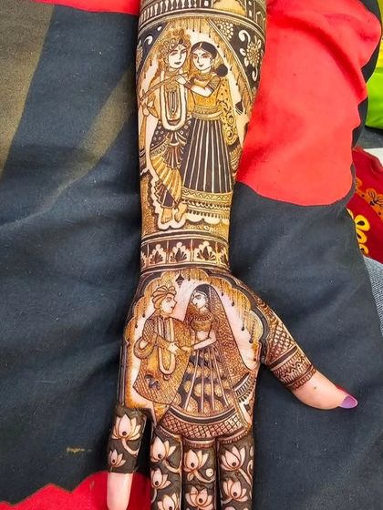 This full-arm design features a portrait of Radha and Krishna on the forearm, with a bridal couple portrait on the palm, blending spirituality with the wedding theme.
