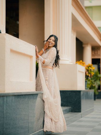 A joyful and candid shot of the bride-to-be laughing. Her natural happiness shines through in this beautiful portrait taken against an elegant architectural background.
