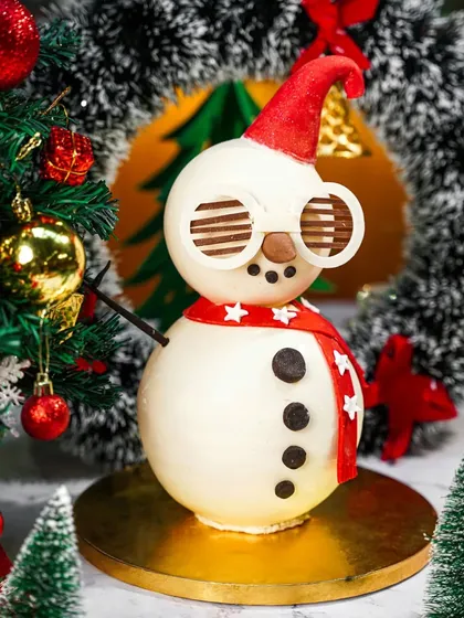 A cool and quirky snowman chocolate creation wearing sunglasses. This playful and imaginative dessert is perfect for a modern and fun Christmas menu.