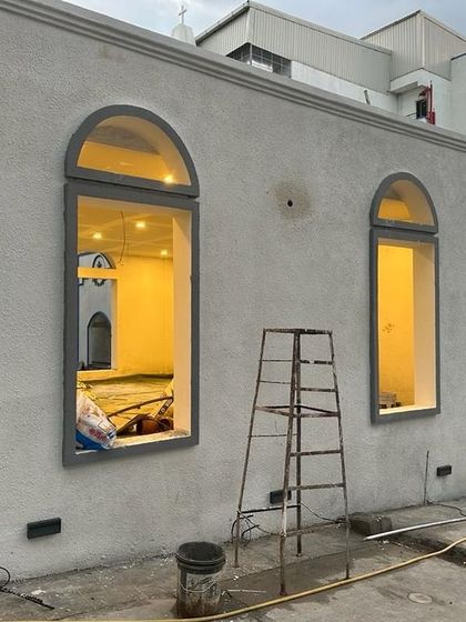 An identical image of the building, showing the finished exterior plaster and window frames.