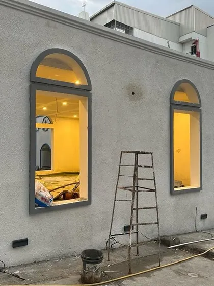 An identical image of the building, showing the finished exterior plaster and window frames.