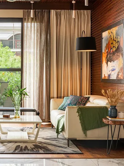 My designs are meant to stand the test of time, blending classic aesthetics with modern comfort. This living area features warm wood paneling, a comfortable leather sofa, and layers of textiles to create an inviting and timeless space.