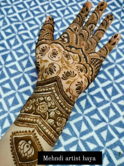A view of the full bridal design, showcasing the elegant flow from the lotus motif on the arm to the detailed work on the fingers.
