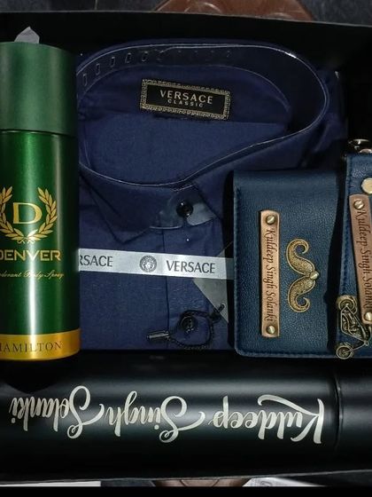 A stylish blue Versace shirt hamper with a personalized wallet, keychain, and a custom flask.
