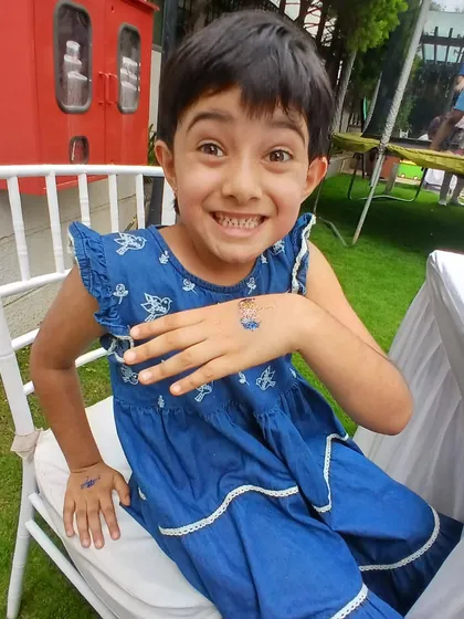 This amazing smile says it all. A simple, sparkly blue glitter tattoo on the hand brought so much happiness, and that’s exactly what I aim to do at every party I attend.