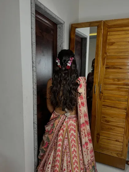 A romantic half-up hairstyle with braids and fresh flowers, perfect for a pre-wedding event.