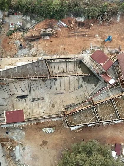 An aerial view showing the early stages of construction for the Himayatsagar Lakehouse. The formwork for the concrete slab reveals the unique footprint of the house.