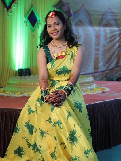 The bride posing happily with her full mehendi during her haldi ceremony.