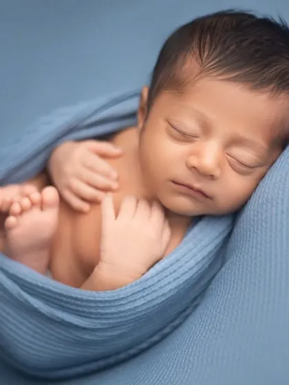 A classic womb-like pose, with the baby snugly wrapped in blue. This pose is very comforting for newborns and results in beautifully peaceful portraits.