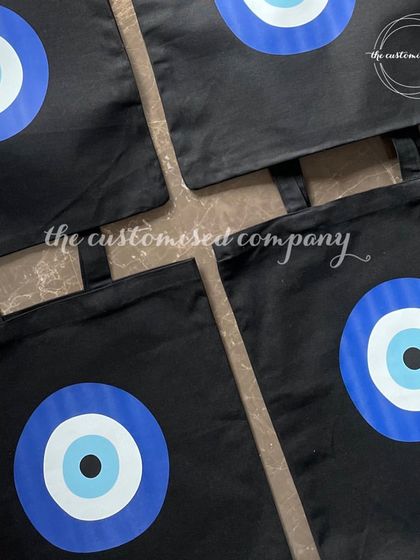 Ward off negativity in style with our evil eye monogram canvas utility bags. These sturdy black tote bags are perfect for everyday use or as a thoughtful gift.