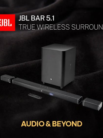 A product shot of the JBL Bar 5.1 system, emphasizing its "True Wireless Surround" capability. The detachable speakers offer a clean, wire-free solution for creating an authentic 5.1 channel audio experience.