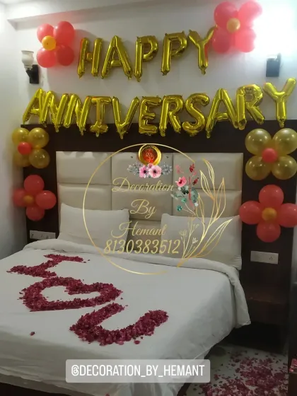 I can turn any hotel room into a romantic retreat. This simple yet classic anniversary decoration includes large foil balloons above the headboard and a personal message written in rose petals on the bed.