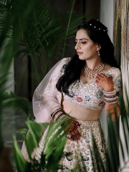 A beautiful portrait of Kirti during her engagement ceremony, framed by indoor plants.