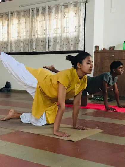 Teaching is a partnership. In this photo, I am guiding a young student through a posture during a kids' yoga session. I ensure each child receives personal attention to help them with alignment and to make sure they are practicing safely and effectively.