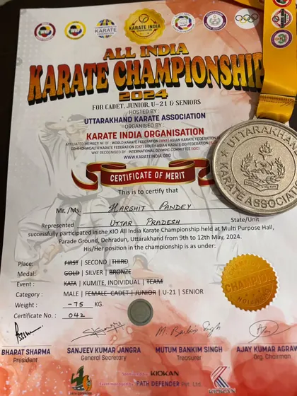 The official certificate of merit and silver medal awarded to Harshit Pandey for his performance in the senior category at the All India Karate Championship.