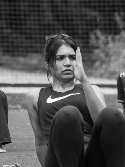 The determination on a participant's face during a core exercise at the StrongHER workshop. These sessions are about pushing limits and discovering your strength in a supportive community.