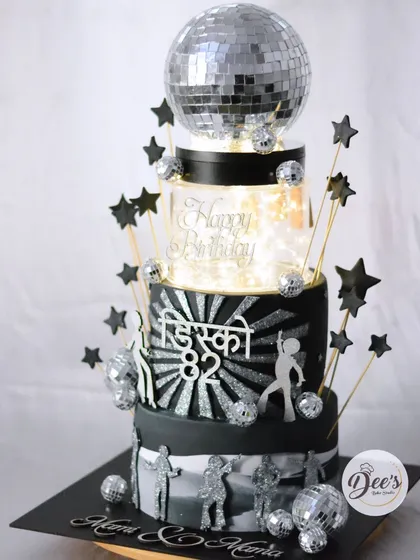Let's bring back the disco era. This four-tier 'Disco 82' themed cake was the life of the party, complete with a spinning disco ball, light-up tier, and sparkling silver details that capture the retro vibe perfectly.