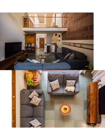 The living room of the Kaustubha Residence, showing a comfortable, modern space with a double-height ceiling over the seating area. The mezzanine level adds another dimension to the room.
