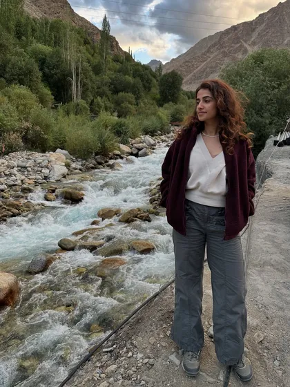 Pausing by a rushing river in a Ladakhi valley. The sound of the water and the stillness of the mountains create a perfect harmony, a natural soundtrack for contemplation and self-reflection.