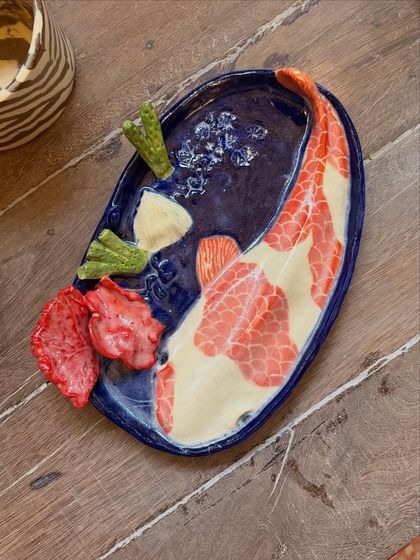This student's quiet patience and steady curiosity shine through in these beautiful pieces from her beginner's course. The whimsical koi pond platter is a favorite, full of texture and calm joy.