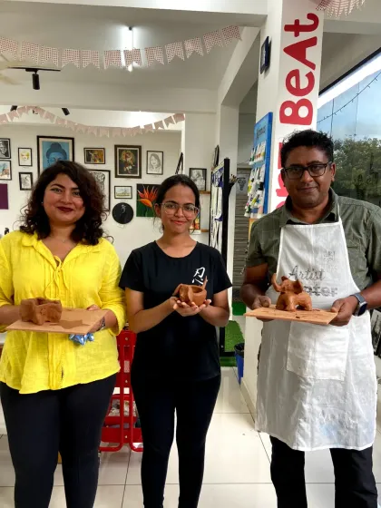 A group proudly displays their finished clay creations. From small animals to functional pots, the possibilities are endless.