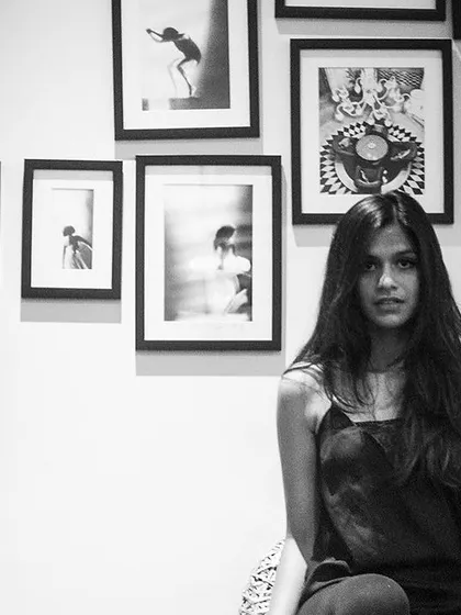 A straight-on portrait from the 'Ignite' series, taken in her personal space, surrounded by her own art.