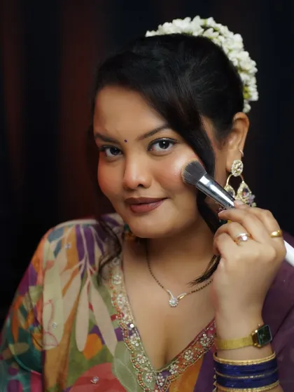 A direct look at the camera while applying makeup, inviting you to join the class.